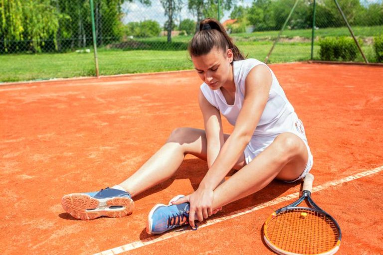 Woman playing tennis feeling effect of sports on your joints.